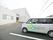 建物外観と、駐車エリアに停められている施設が所有する車である。ワゴンタイプの車に施設名のペイントが施されている。