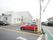 駐車場入り口に施設名の看板が設置されている。道路から見やすい場所にある。施設建物と駐車エリアは同じ敷地内にある。