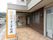玄関前の歩道沿いに縦長の看板がある。提供サービスと施設名称が、カラフルなロゴマークとともに表示されている。