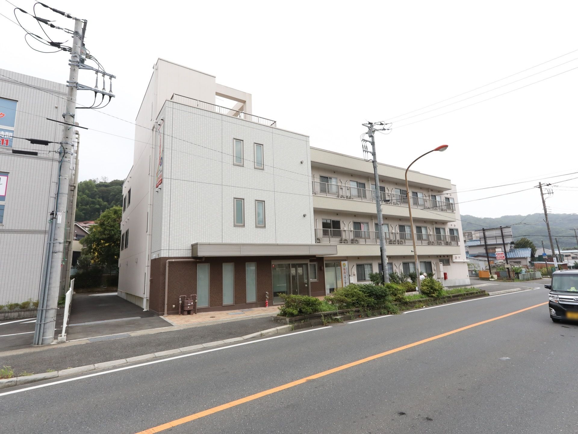 片側一車線の道路沿いに立地している３階建ての施設である。玄関付近以外は白色を基調とした外壁になっている。