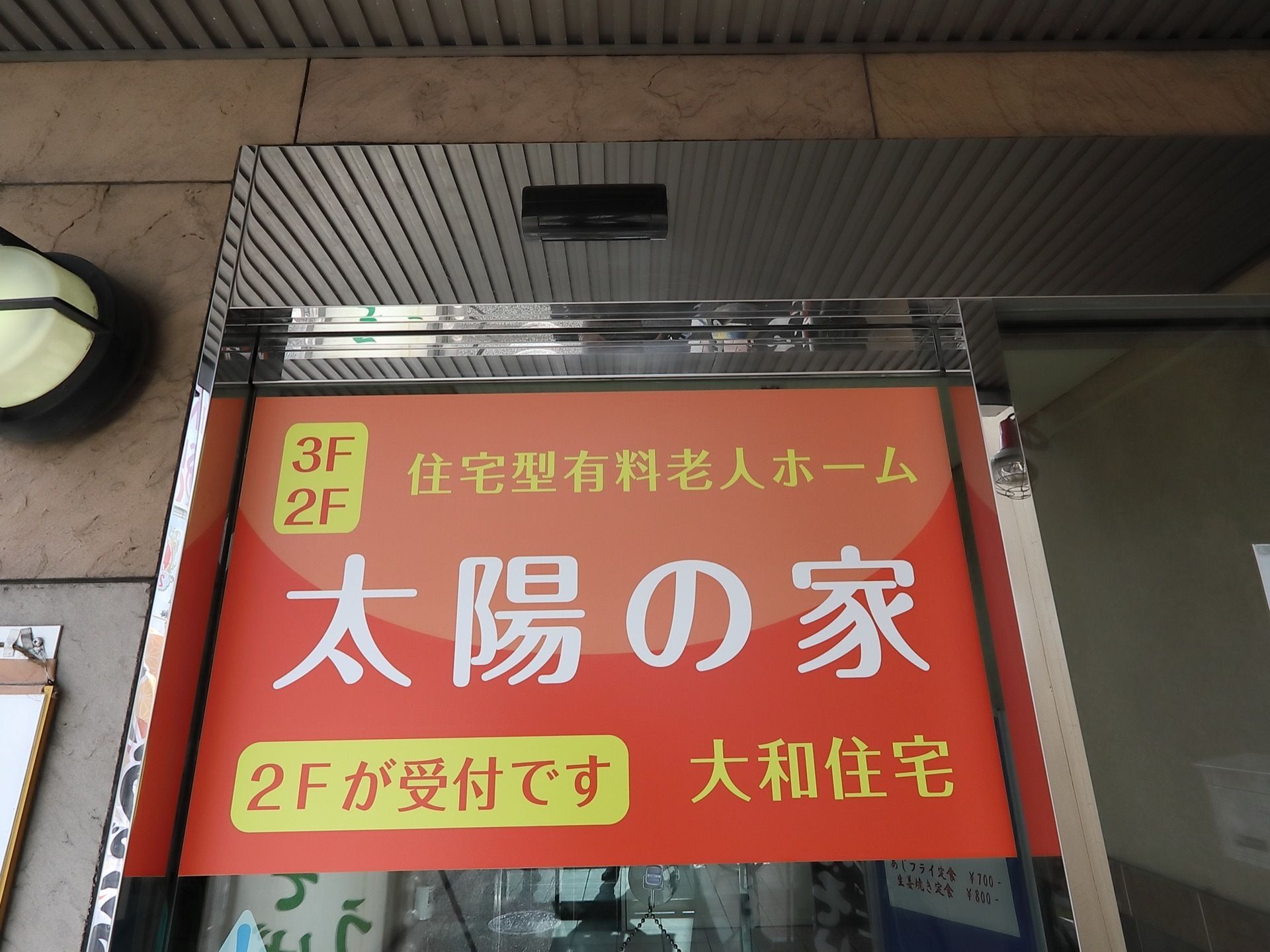住宅の集合玄関は自動ドアになっている。ドアの上半分にはホーム名が書かれ、横には照明が設置されている。