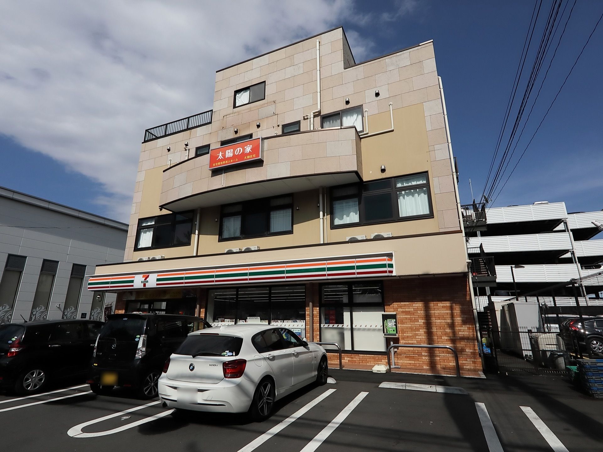 建物の１階部分にはコンビニエンスストアが入っていて、駐車場がある。２階から上がホームの住宅スペースになっている。