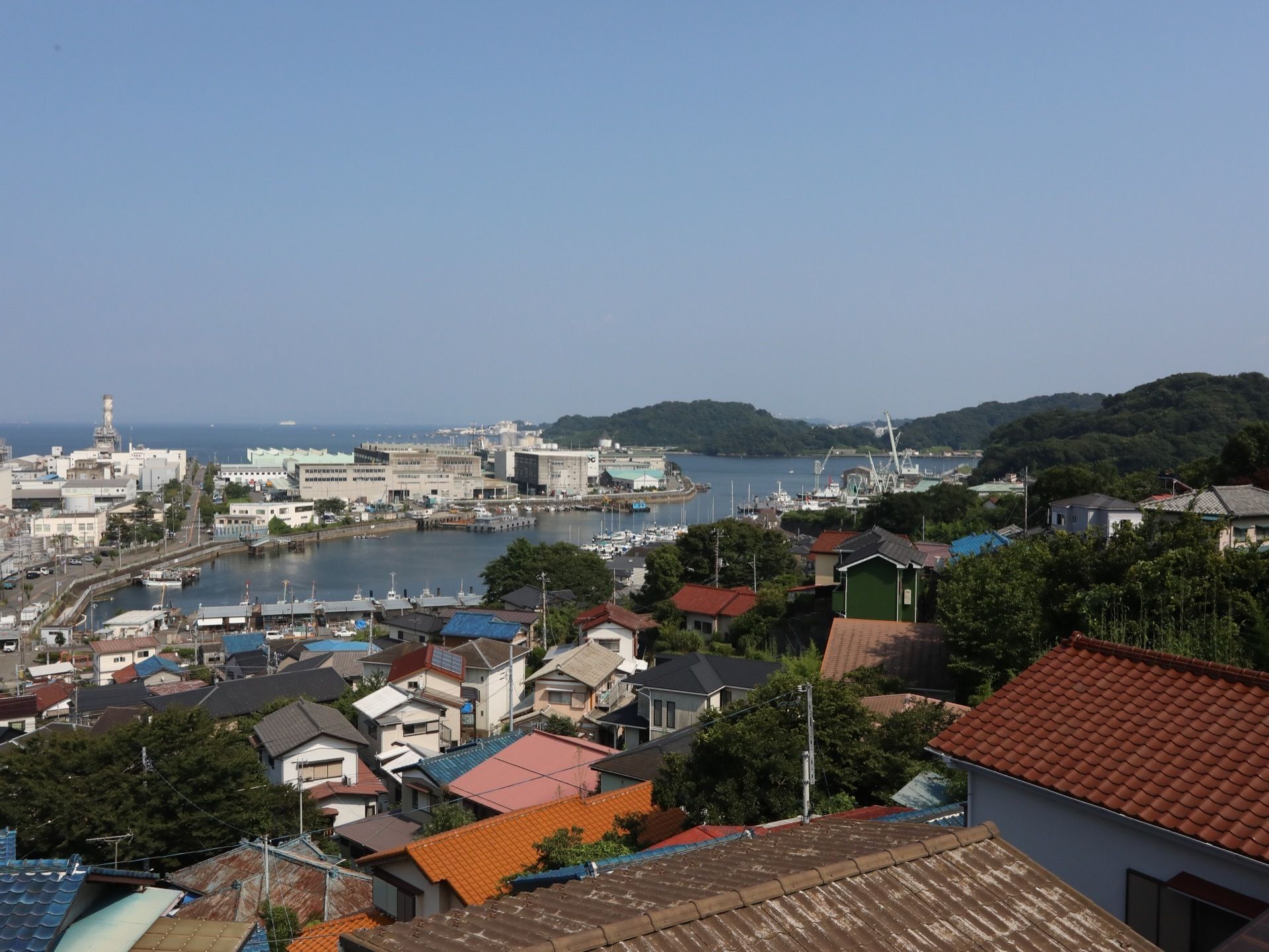 住宅や港を建物から臨むことでき、遠くには木々の生い茂った島も見える。美しい海もある自然に囲まれた立地である。