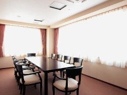 カーテンが付いた大きな窓がある部屋には10人掛けの大きなテーブルセットが置かれている。