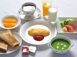 オムレツやカットオレンジ、コーヒー、ジュース、スープ、サラダ、トーストなどが並んでいる。