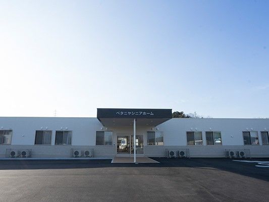平屋建ての建物。敷地は広く、駐車スペースもある。