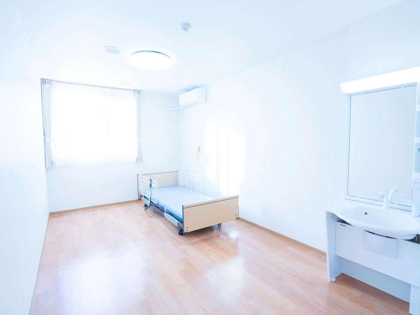 日当たりのいい居室は広々としたフローリングの部屋。車いす対応の洗面所が付いている。