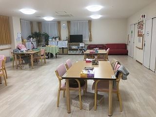 大きな窓がたくさん付いた食堂には4人掛けのテーブルセットが複数置かれ。大きなテレビもある。