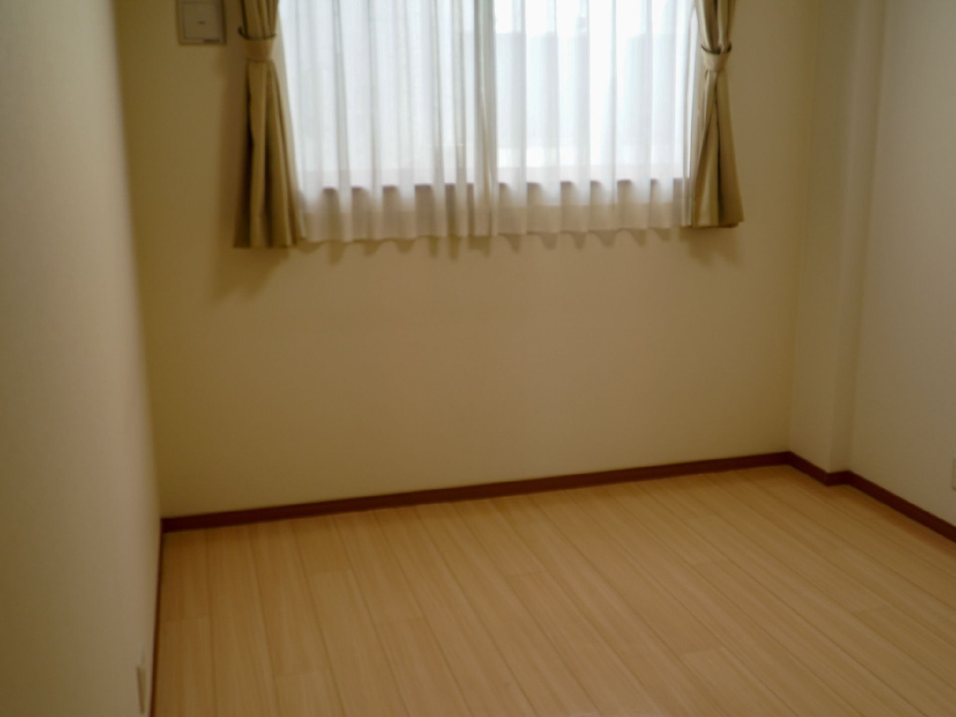 窓にカーテンが掛けられた洋室