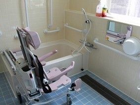 車いすタイプのリフトが設置された浴室には、一人用の浴槽が設置され、手すりが付いている。