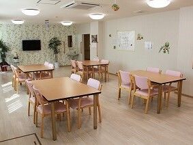 4人掛けのテーブルセットが複数置かれた食堂には壁掛けテレビもあり、手作りの装飾品が飾られている。