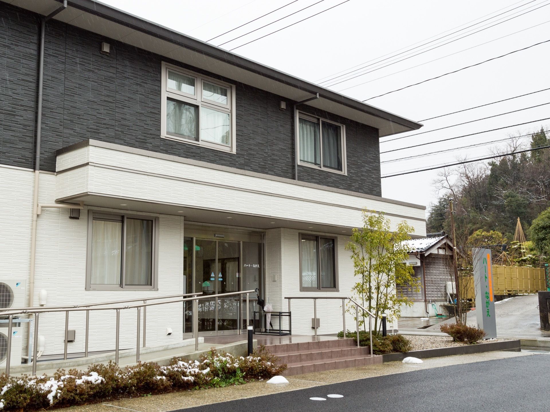２階がグレーで、１階がホワイトの外装をした建物である。自動ドアの正面に階段があり、向かって左側にスロープが設けられている。