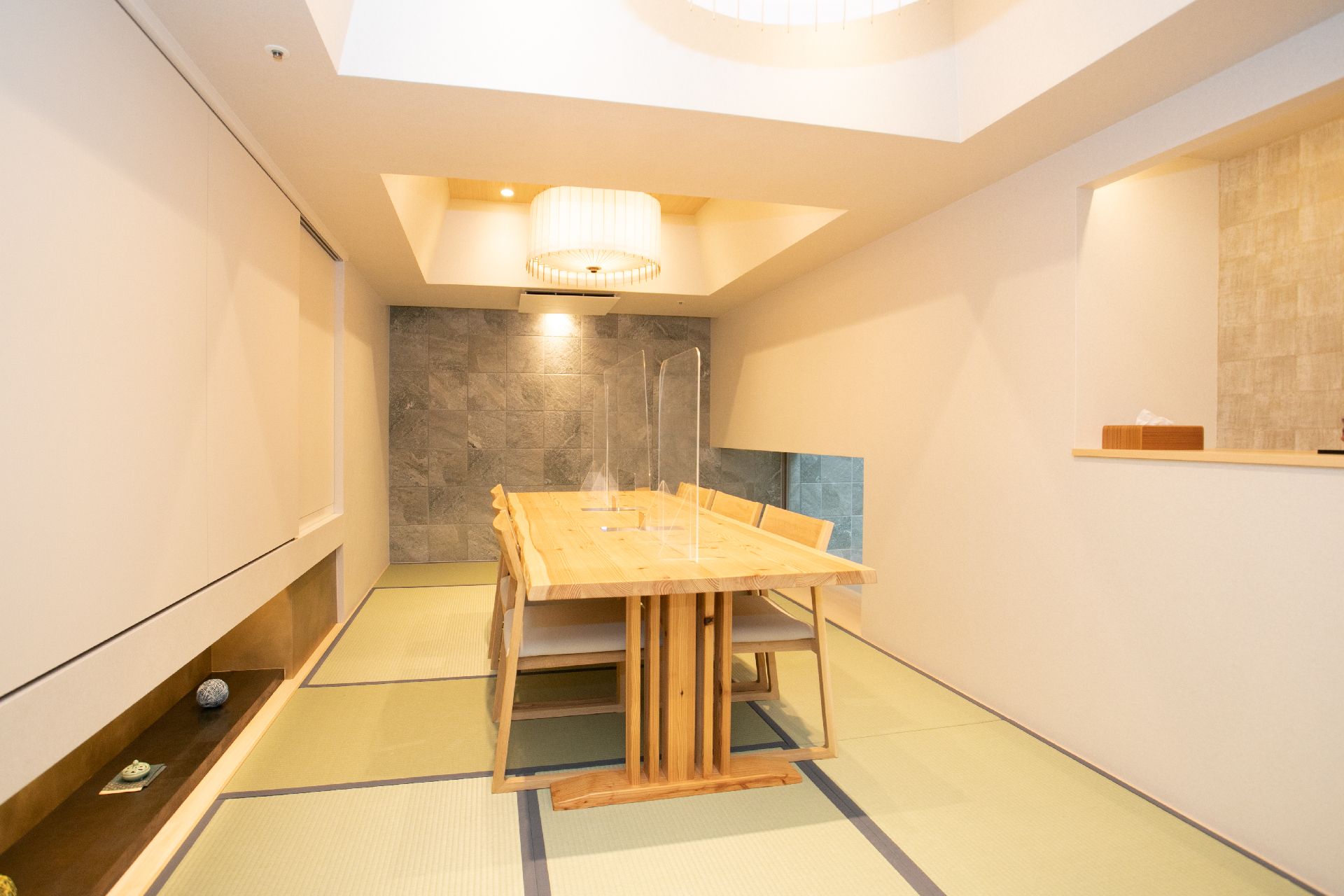 テーブルを挟んで椅子が設置され、床には畳が敷かれている部屋