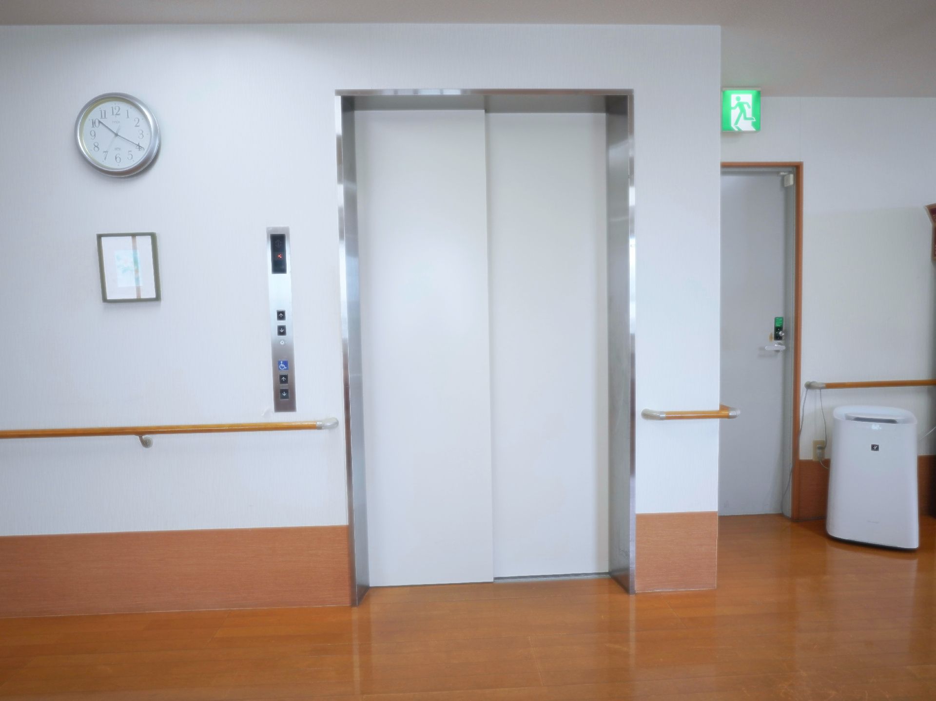 白い壁に配置された白い扉のしまったエレベーター