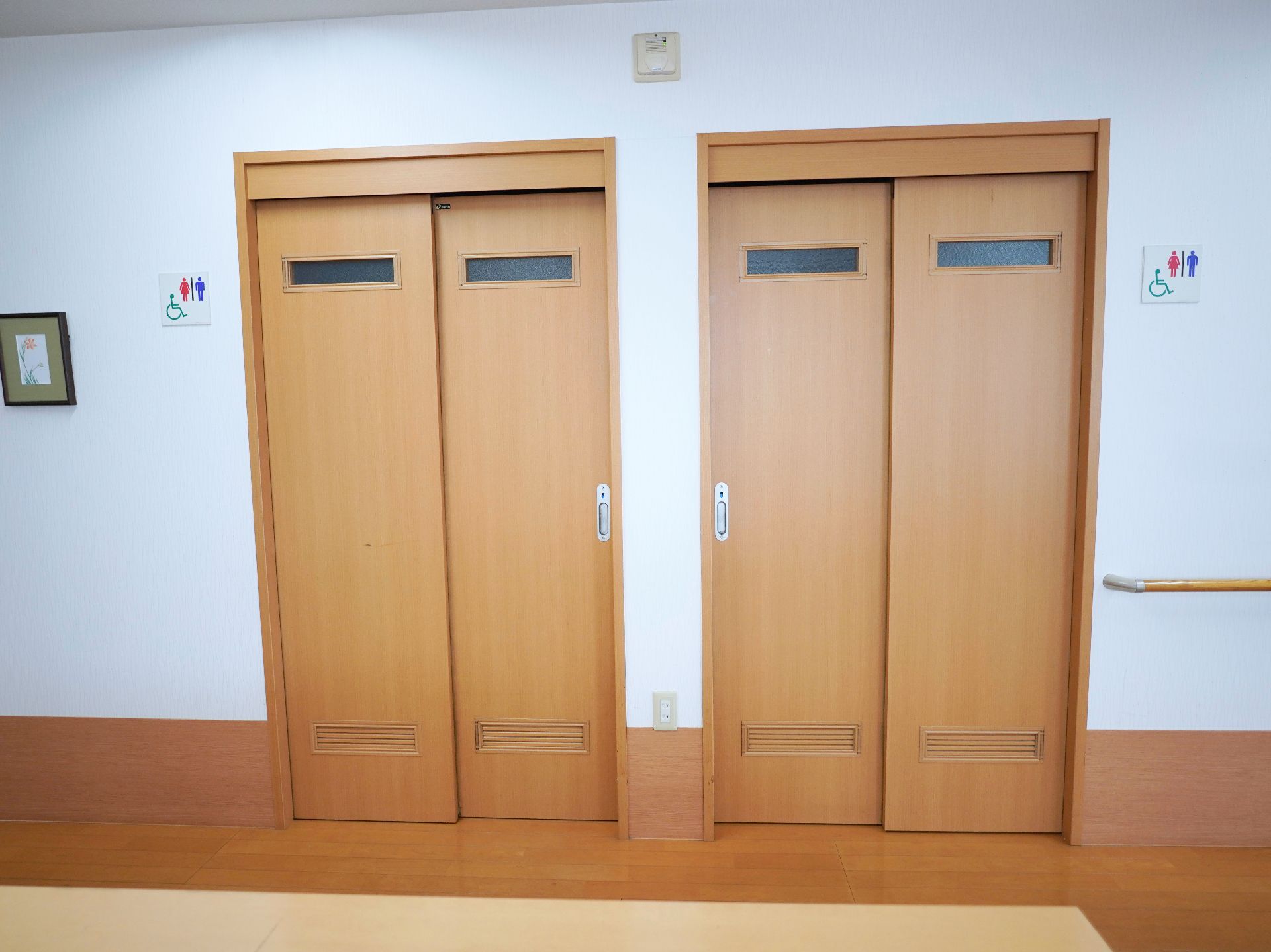 白い壁に配置された木製でスライド式の２つの扉