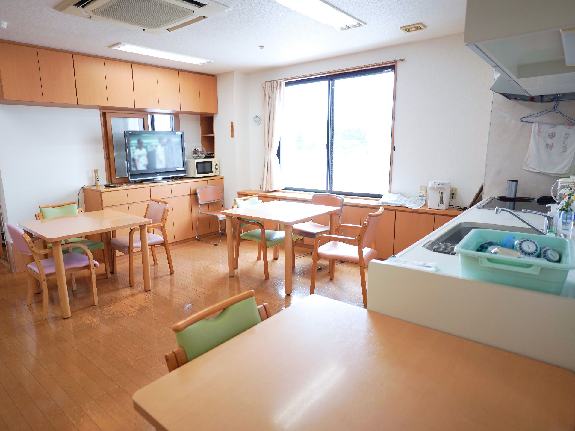 木製の机が置かれた白い壁の部屋
