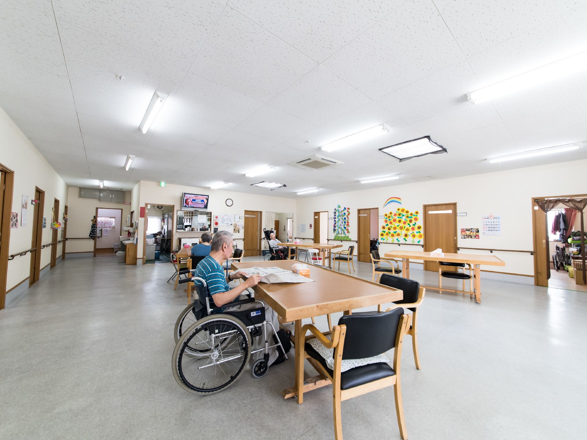 余裕を持った広さのリビングダイニングである。居室前のスペースに位置している。車椅子の方も席に着けるダイニングテーブルがある。