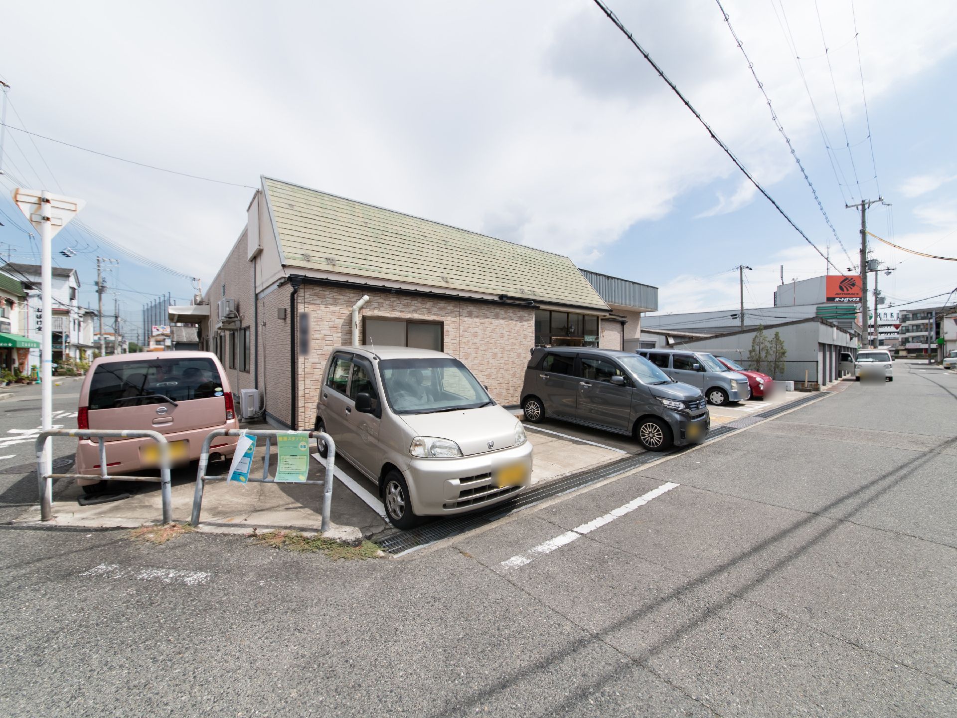 緑の屋根と壁がベージュ色の施設である。正面に駐車場が設置されており、建物の横にも車を止めることが可能。