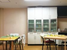 ダイニングテーブルが二つ、大きな白い食器棚が一つ置かれている食堂。