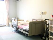 ベッドや収納家具が置かれた居室はカーペット敷きで大きな窓が付いている。