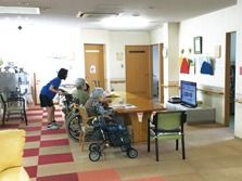 リビングでは車いすの入居者が数名テーブルについている姿が見える。