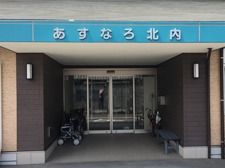 玄関には大きな屋根が付き奥にはガラスの自動ドアが見える。