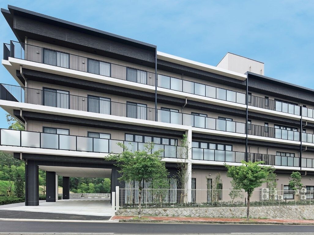 4階建てで各階にベランダがあり、1階にはピロティが設けられている建物