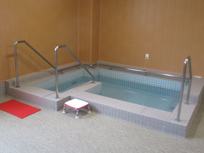 浴槽内に置くいすが置かれている。浴槽は大きく、出入り口の浴槽の周りには手すりが付いている。