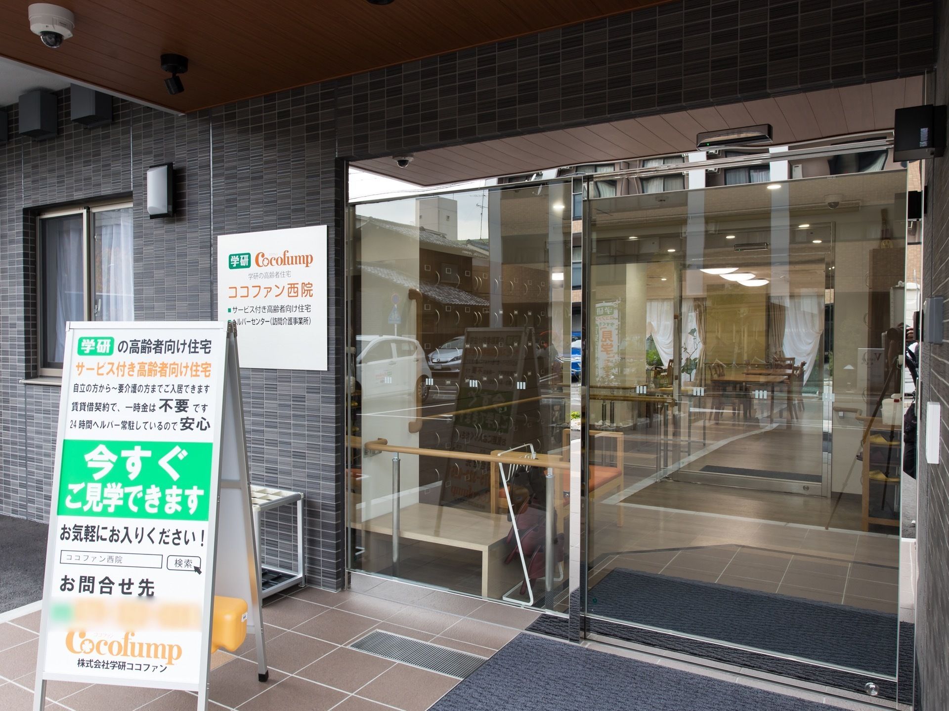 施設の玄関は大きな自動ドアで、ガラス張りである。屋根が設置されており、防犯カメラが天井に取り付けられている。