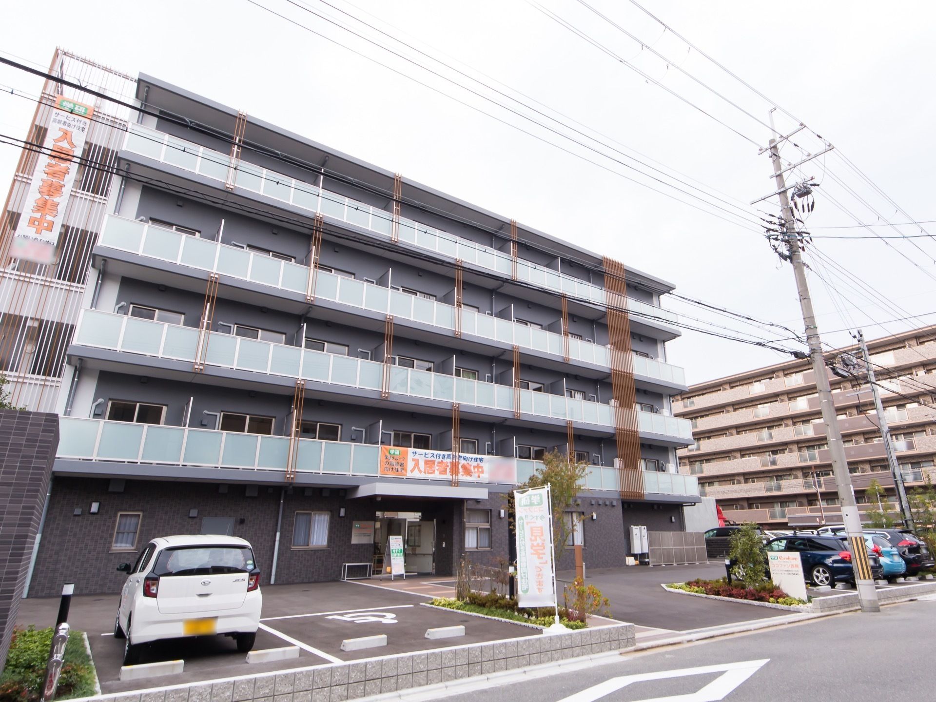 施設は５階建ての大きな建物である。大きな駐車スペースが建物前にあり、車椅子をご利用の方専用のスペースが用意されている。