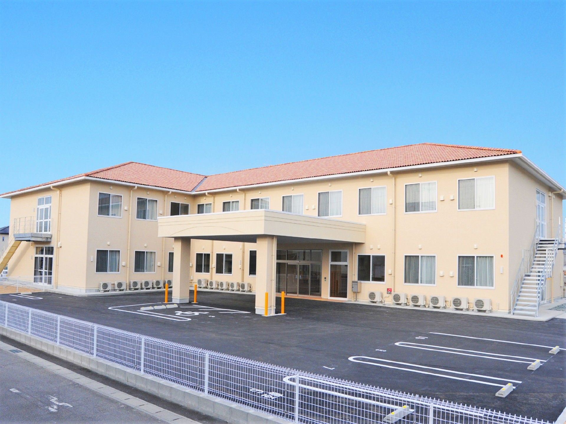 玄関に車寄せが付き、２階建てでエル字型の建物となっている。広い駐車場付きのホーム。