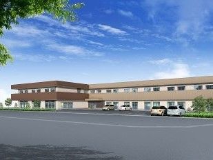 ブラウンを基調とした２階建ての建物。広い駐車場もある。