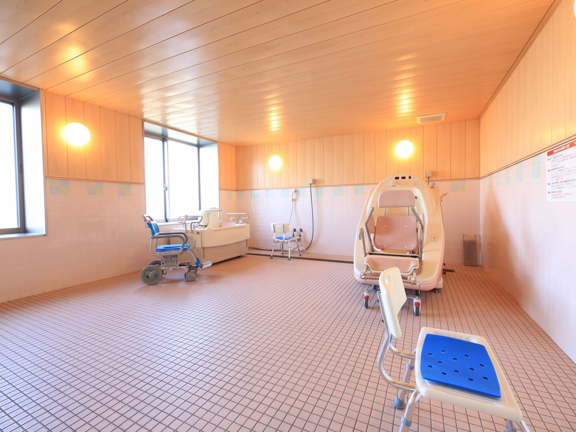 床一面がタイル張りになっている広い浴室がある。大きな窓が２つあり、壁には照明器具が付いている。入浴用の機材が２つ置かれている。