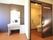 居室にある、引き戸の付いた個室のトイレと洗面台がある。洗面台には大きな鏡と棚が付いており、壁の一部が黒く塗られている。