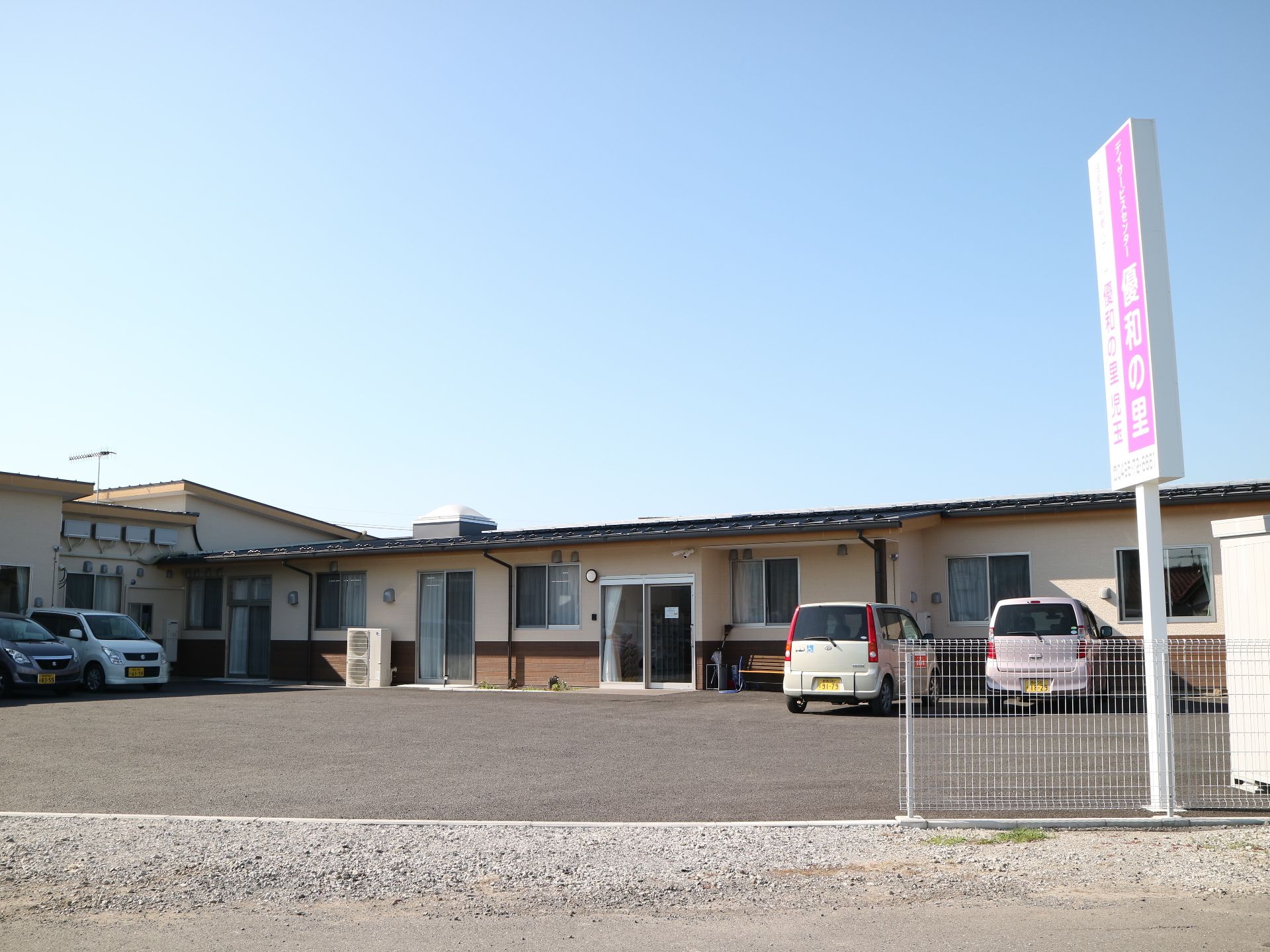 駐車場スペースを広く設けている平屋建ての施設の外観