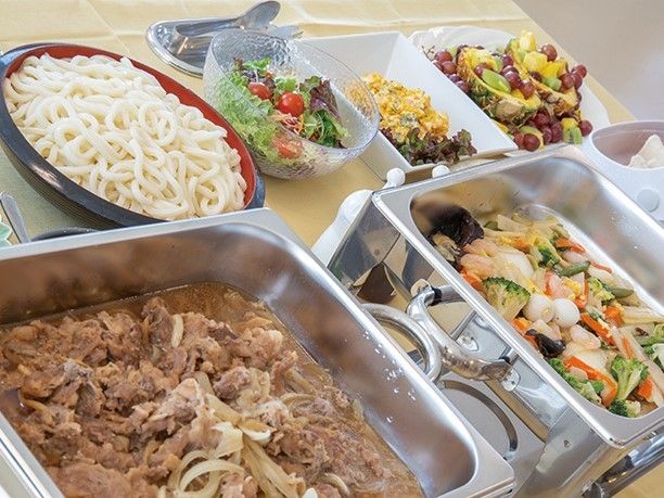 バイキング形式の食事メニュー。色とりどりの野菜や肉、麺類が並んでいる様子