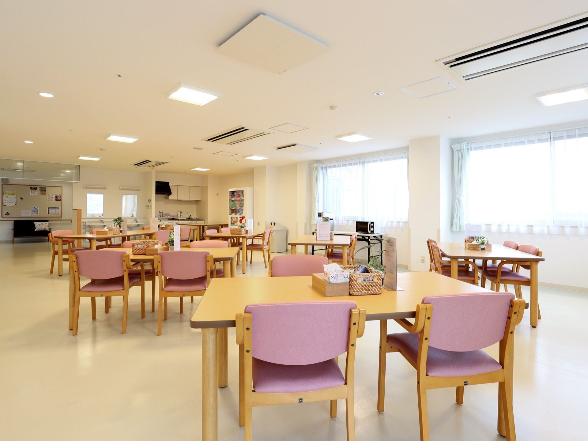 日当たりが良く、開放的な食堂である。四角いダイニングテーブルがいくつも用意されている。自動販売機がある。