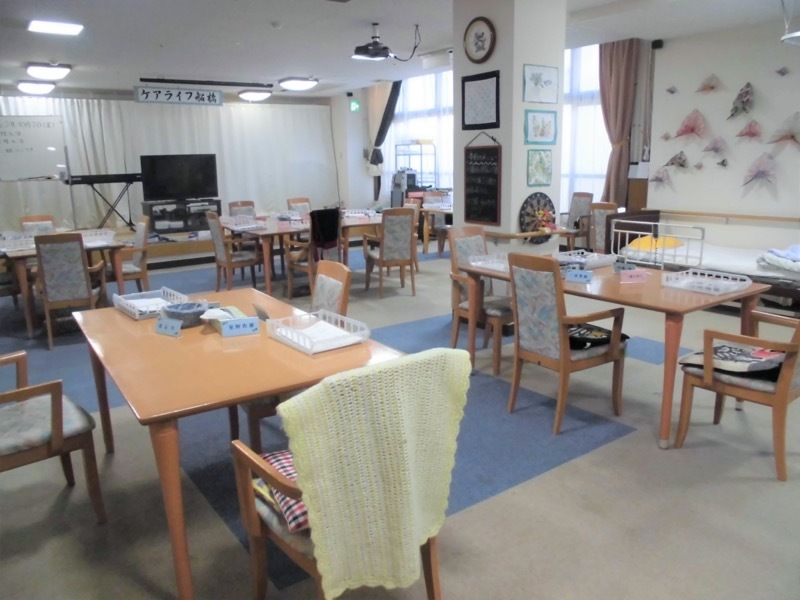 利用者の作った作品がたくさん飾られていて、テーブルの上には創作活動の材料のようなものが置かれている。