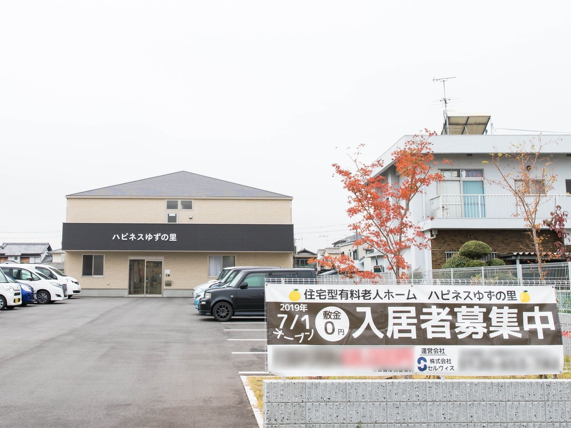 入居者募集中の案内が大きく、見やすく掲示してある。施設前には広い駐車場を完備している。入り口は自動ドアである。