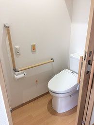 L字型の手すりと緊急コールがついた施設のトイレ。居室用のトイレの様子