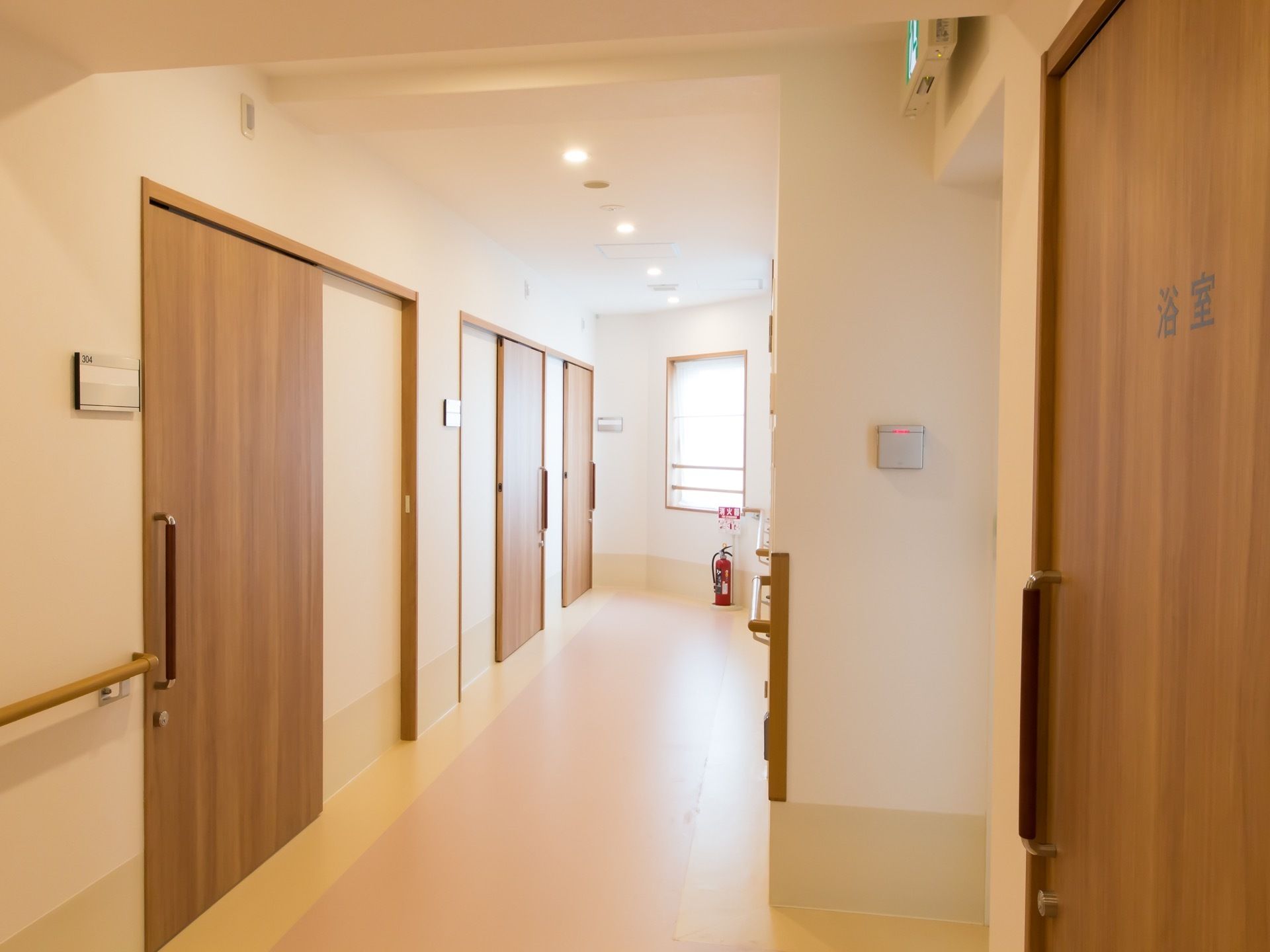 通路右側には浴室の扉がある。左側には居室が並んでおり、扉横に各部屋番号が振り分けられている。突き当りには窓があり、消火器が置かれている。