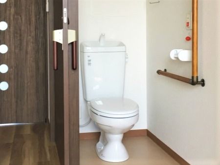 手すりや呼び出しボタンが付いたトイレはシンプルな造り。