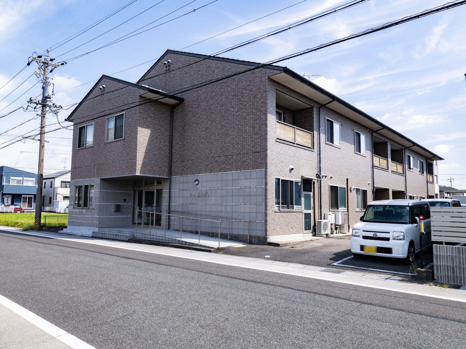 女性の肩を持ちながら笑顔で何かを眺めるスタッフ。施設で笑顔になっている場面