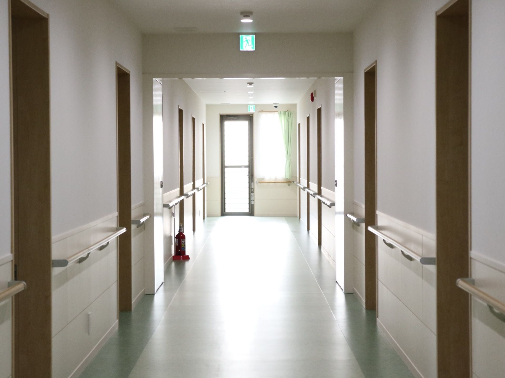 ドア部分を除く廊下の壁全面に、手すりが付けられている床には消火設備以外の物が置かれておらず、すっきりしている。