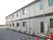 ２色のツートンカラーの外壁を持つ２階建ての施設である。エアコンの室外機がたくさん並べて置かれている。