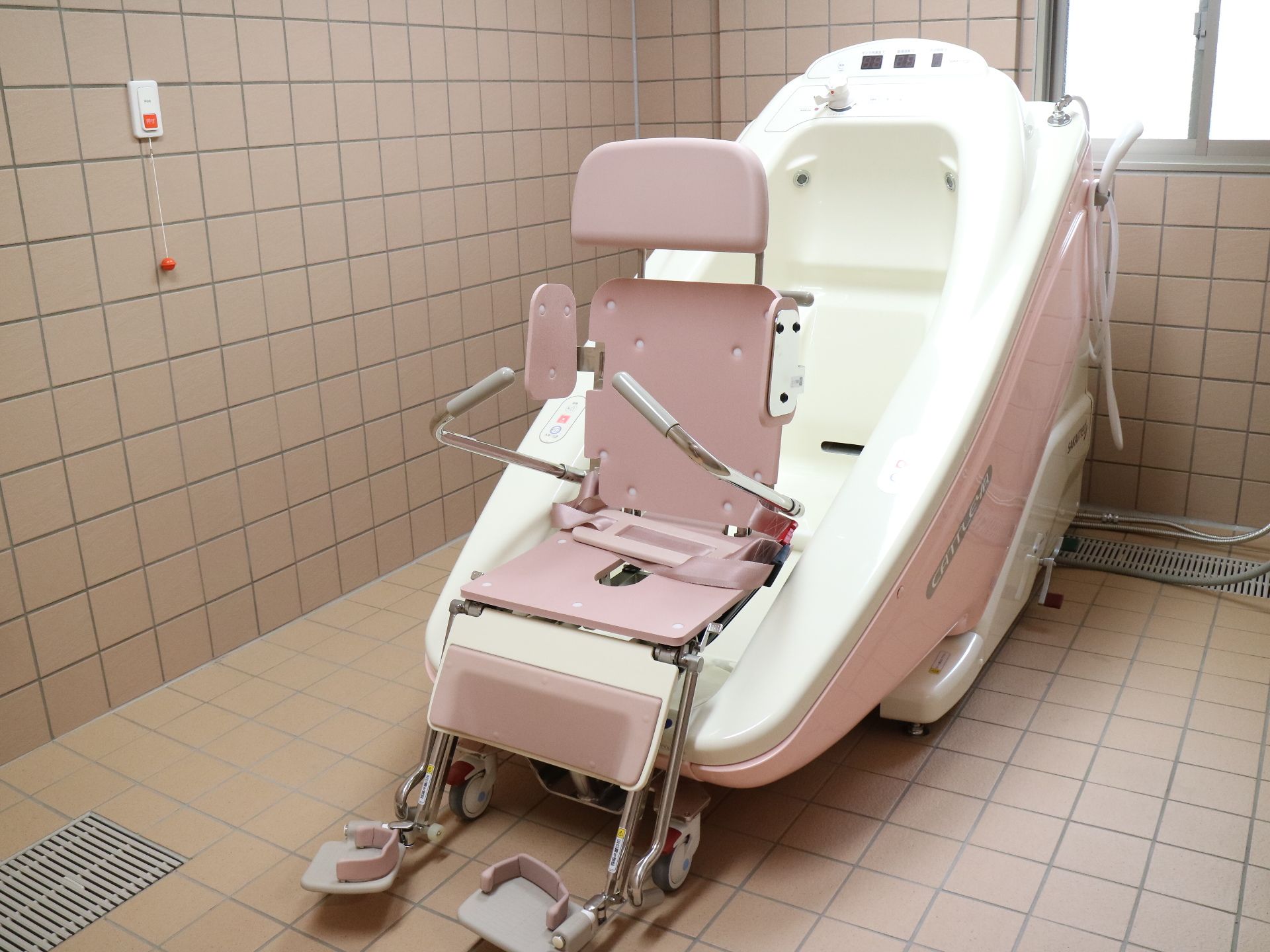 要介護者を腰部分でベルトに固定し、座ったまま入浴が可能な特殊浴槽