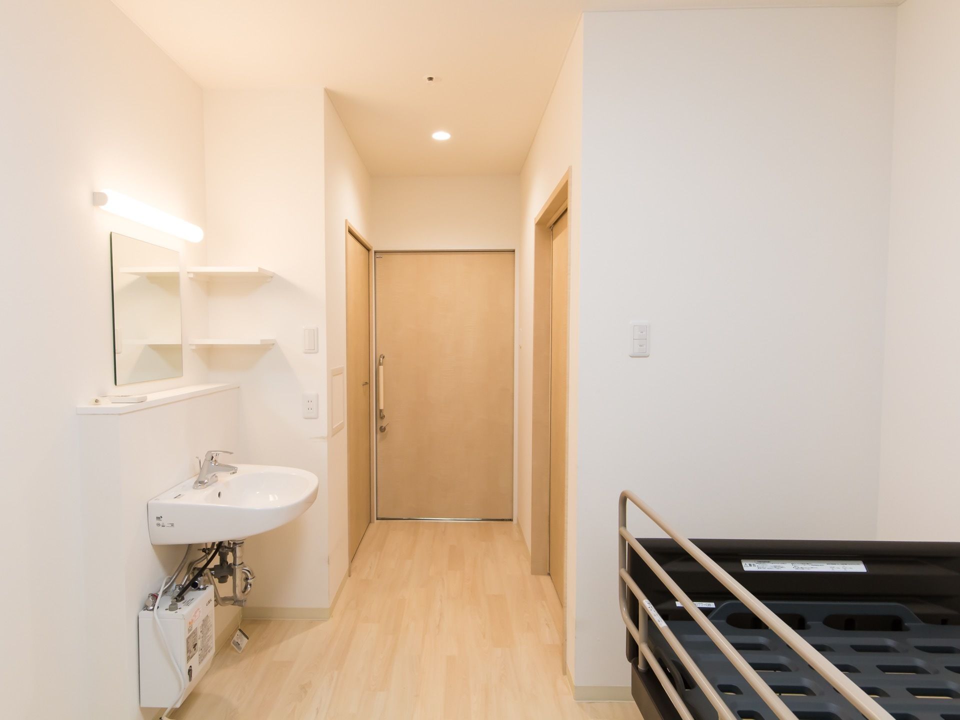 居室内部の様子。玄関ドアの近くには個室トイレに収納、洗面台と言った場所を取る設備が集中している。天井にはエアコンがある。