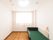 フローリングの床に白い壁の部屋で、右側にベッドが一台置かれている。ベッド脇の壁にナースコールが設置されている。