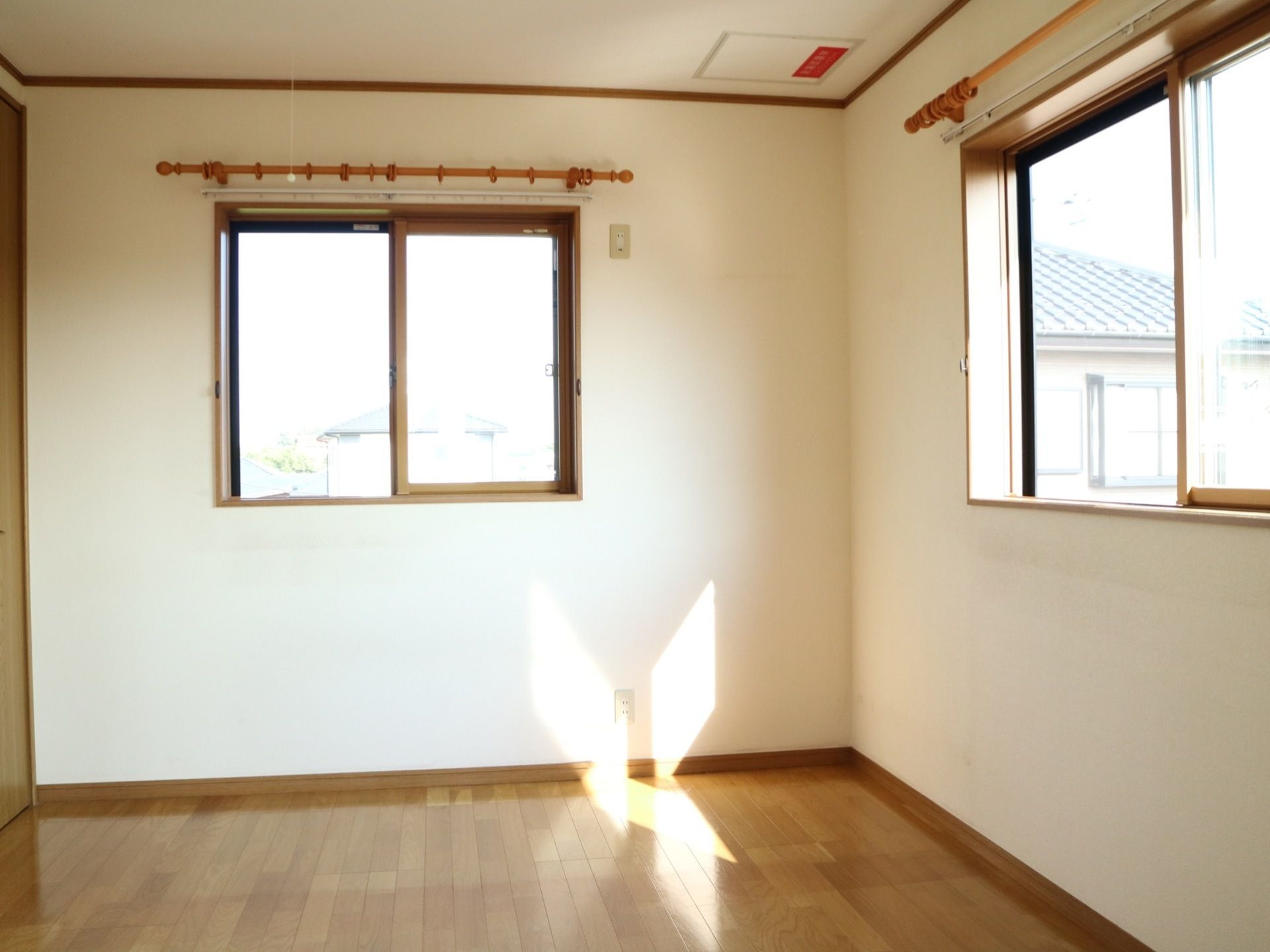 木目調のフローリングである。白い壁には窓が一箇所づつ設置され、それぞれにカーテンポールが取り付けられている。