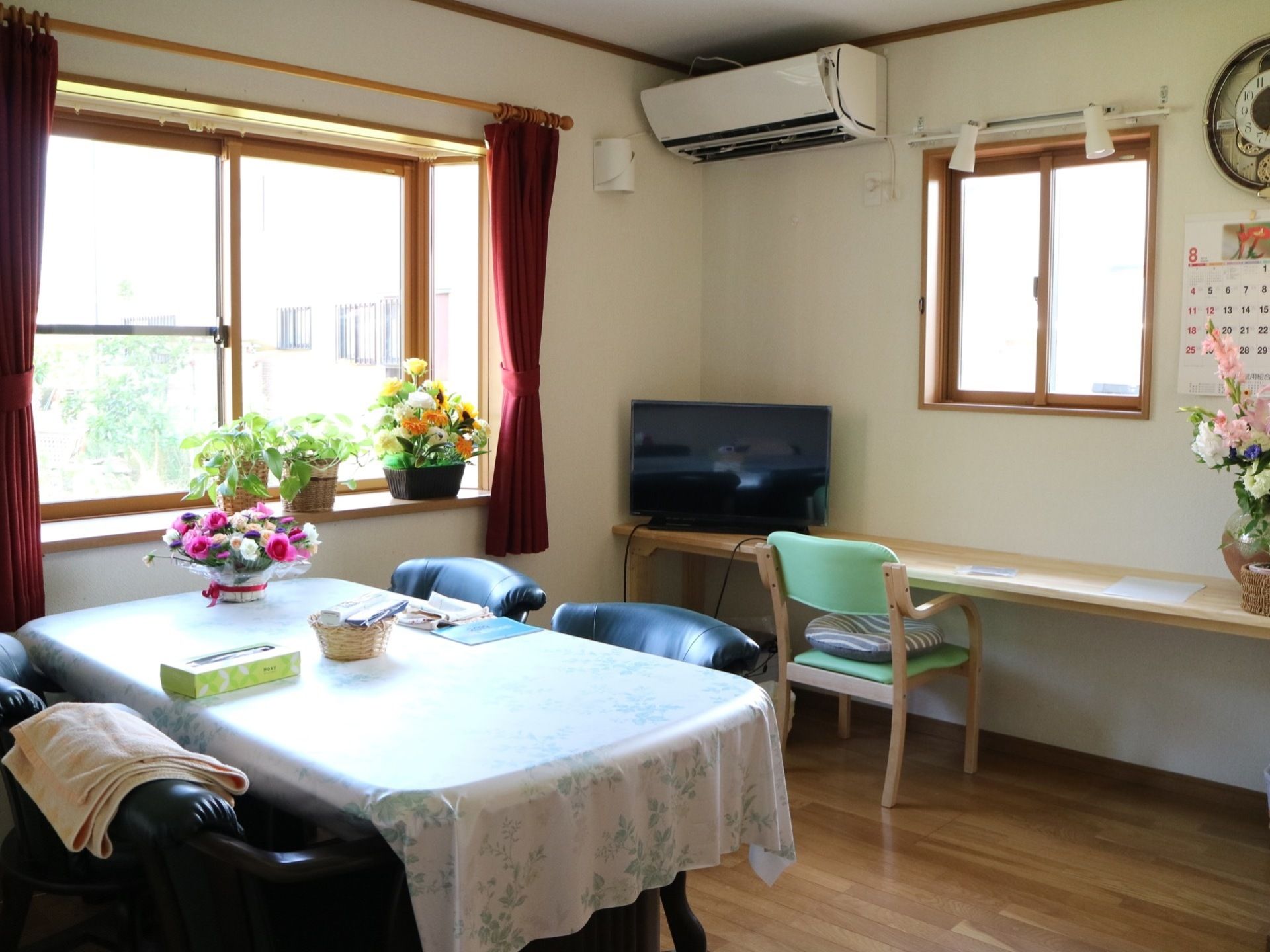 出窓が完備された共有スペースである。４人がけ用のテーブルのほかにテレビが置かれたカウンターテーブルが設置されている。